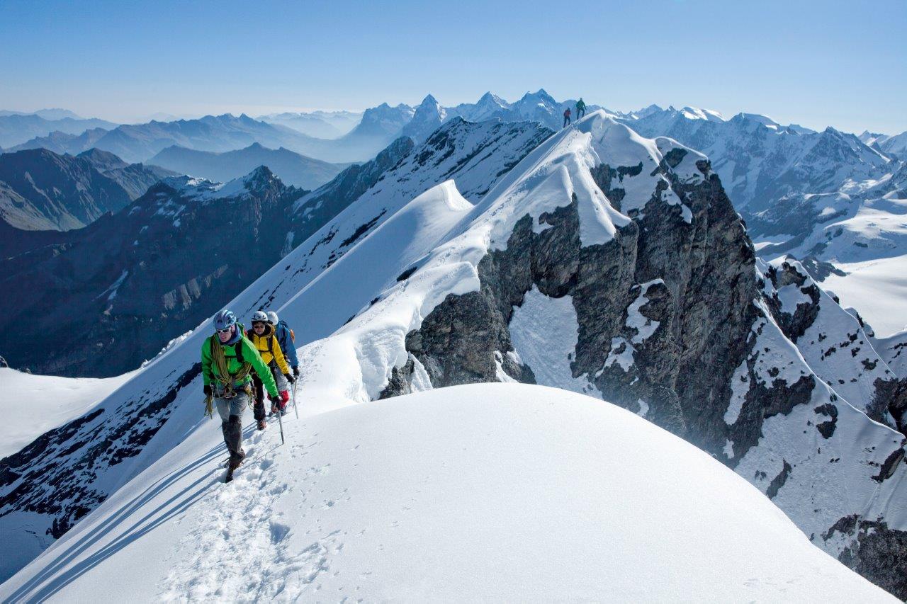 Tras los alpinistas que acceden a la cima del  Bluemlisalphorn se ven el Eiger, Moench y Jungfrau. (Copyright/ST/Swiss Image).